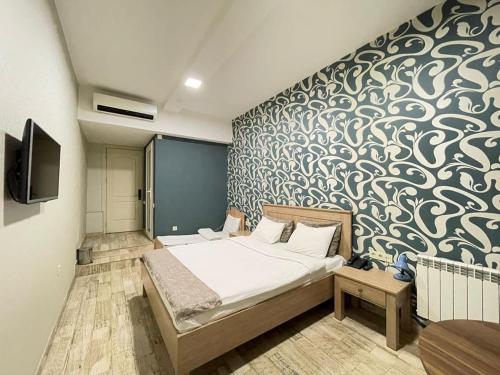 巴库Nizami Street Hotel的一间卧室配有一张床和壁画墙
