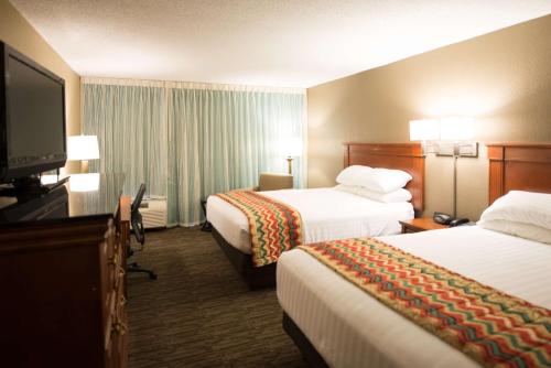 开普吉拉多开普吉拉多医疗中心梨树酒店的酒店客房设有两张床和一台平面电视。