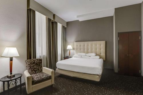 新奥尔良Drury Plaza Hotel New Orleans的配有一张床和一把椅子的酒店客房
