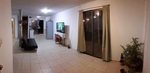 皮卡Cabaña en Pica con Jacuzzi privado的客房设有带电视和沙发的走廊。