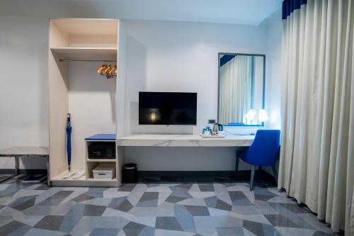 宿务Stacia Hotel powered by Cocotel的浴室设有白色的办公桌和蓝椅。