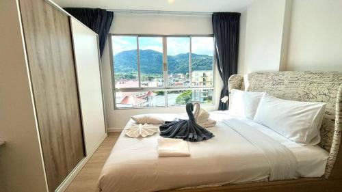 卡图Top Floor One Br Apartment Between Patonghkt City的一间卧室设有一张大床和大窗户