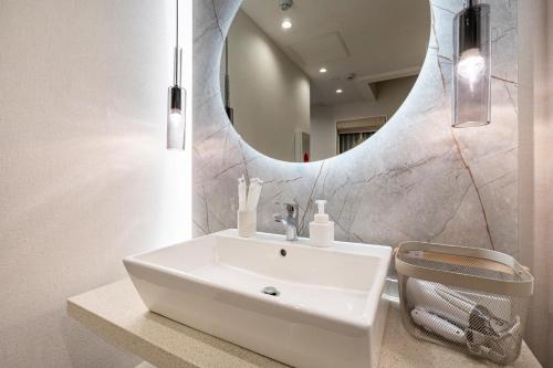 东京Hotel STAY ARI Higashishinjuku的浴室设有白色水槽和镜子