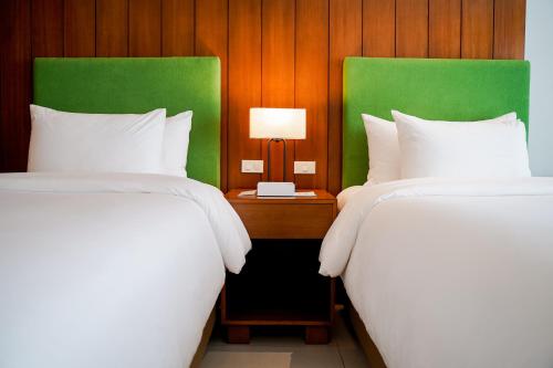 San MateoTimberland Highlands Resort的配有两张床铺的酒店客房 - 带台灯的桌子