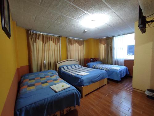 拉塔昆加HOTEL CARIBEAN REAL的黄色墙壁客房的两张床