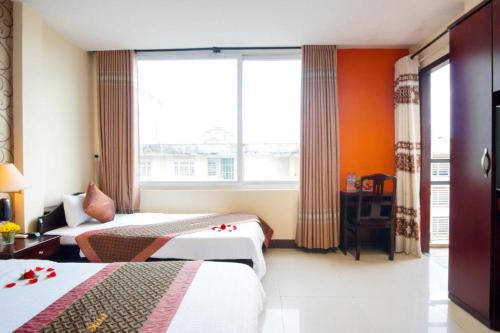 顺化DMZ酒店的酒店客房设有两张床和窗户。