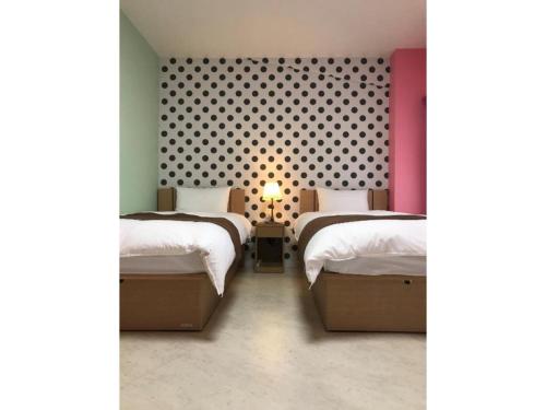 川口市WALLABY HOUSE - Vacation STAY 38651v的一间卧室设有两张床,墙上设有波卡点