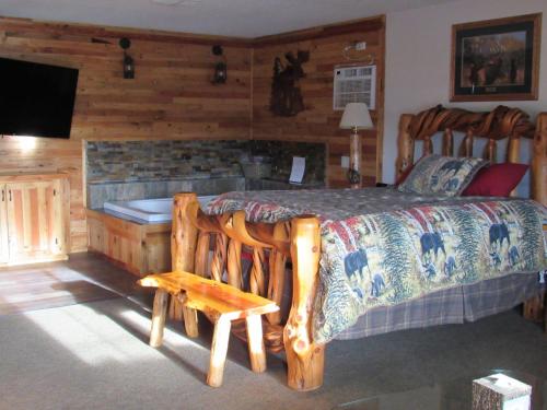 CrescentThe Woodsman Country Lodge Motel的一间卧室设有一张大床和一个壁炉