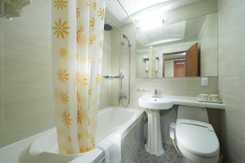 首尔豪门酒店的浴室配有卫生间、浴缸和水槽。