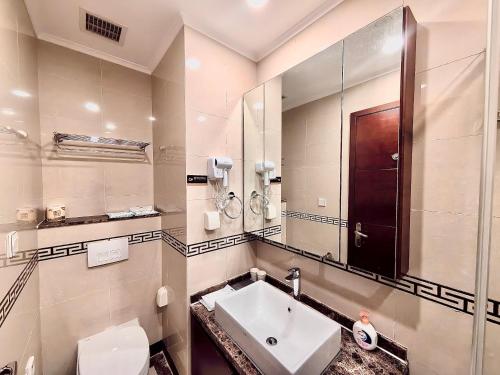 青岛青岛易达屋酒店公寓的一间带水槽、镜子和卫生间的浴室