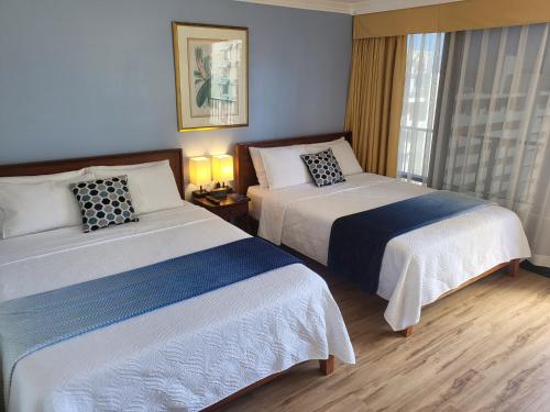 檀香山21st Floor Renovated Studio with 2 Queen Beds的酒店客房设有两张床和窗户。