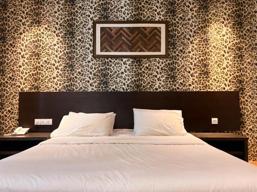 吉隆坡Cube Plus Signature Hotel OUG Kuala Lumpur的一间卧室配有一张白色的床和黑色床头板