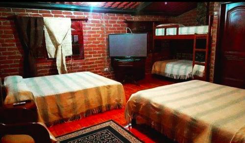 阿劳西Rancho los Emilios的一间卧室配有两张双层床和电视