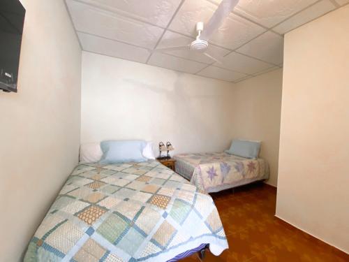 JuayúaMARIA III HOSTAL的一间卧室设有两张床和天花板