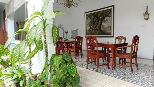 日惹格里亚阿西旅馆的用餐室配有桌椅和植物