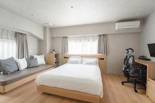 福冈脈 -MYAKU PRIVATE SAUNA-的一间卧室配有一张床、一张桌子和一张沙发