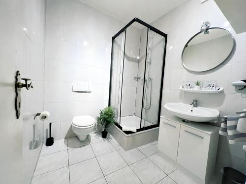 爱尔福特林登内克公寓式酒店的带淋浴、卫生间和盥洗盆的白色浴室
