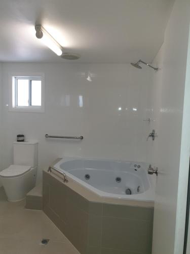 福斯特Forstay Motel的白色的浴室设有浴缸和卫生间。