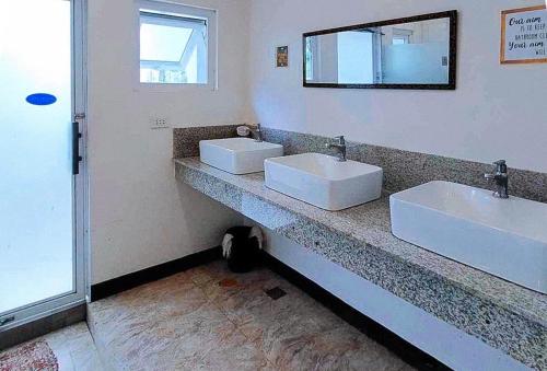 科隆RedDoorz @ Recson Hostel Coron Palawan的浴室设有2个白色水槽和镜子