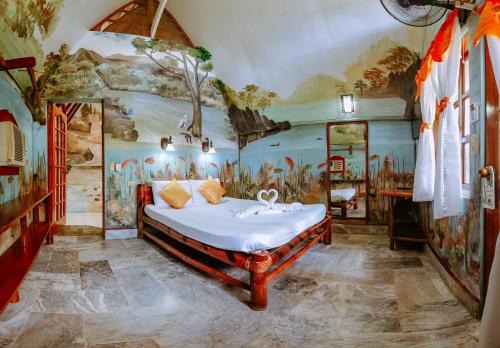 科隆椰子花园度假酒店的壁画客房内的一间卧室,配有一张床