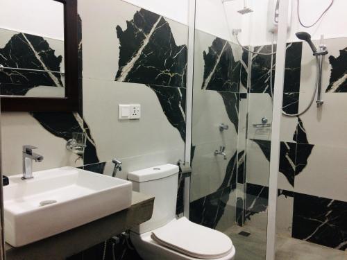 阿鲁甘湾Tropicana Home Stay的浴室配有卫生间、盥洗盆和淋浴。