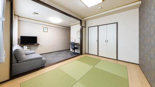 东京Tabist Hotel New Washington Shibuya的客厅设有门、沙发和电视