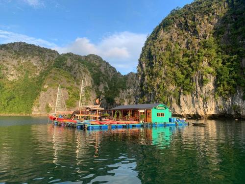 吉婆岛Eco Floating Farm Stay Cai Beo的山边的水中小船