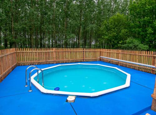 NyársapátBéke Tanya Hongarije的后院的游泳池,带有木栅栏