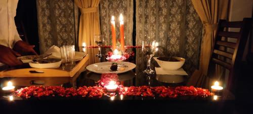 伊都基Paadi Holidays Idukki的一张桌子上放着蜡烛和红色的鲜花