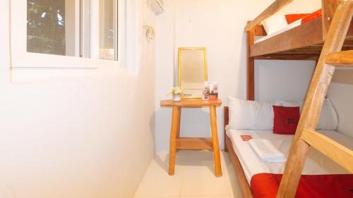 RizalRedDoorz @ Cristina's Hideaway Resort Tanay的一间卧室配有一张双层床和一张带镜子的桌子