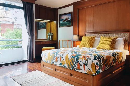 曼谷帕纳莱之家别墅的一间卧室配有一张带木制床头板的床