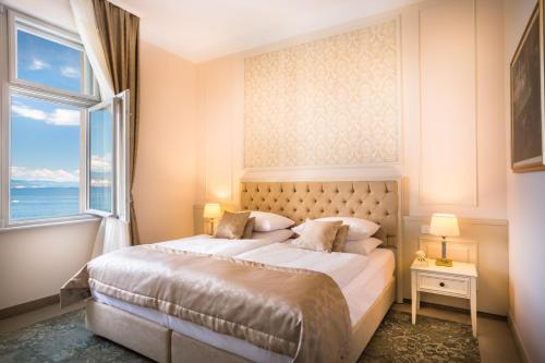 奥帕提亚Hotel Palace Bellevue - Liburnia的一间卧室设有一张大床和大窗户