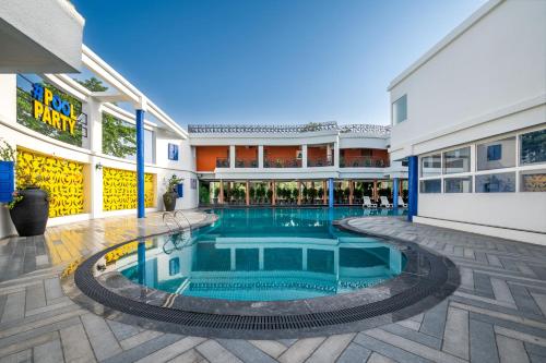 KanījRoadies Rostel - Best Adventure Resort in Ahmedabad的一座建筑物中央的游泳池