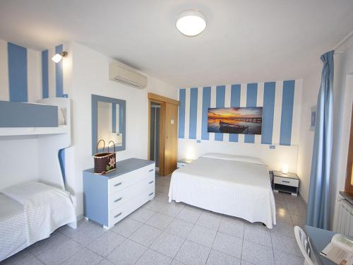 ChiessiHotel Aurora的一间卧室配有两张床,并拥有蓝白条纹