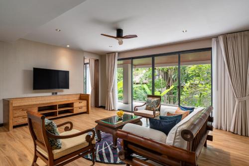 查龙Noku Phuket的带沙发和电视的客厅