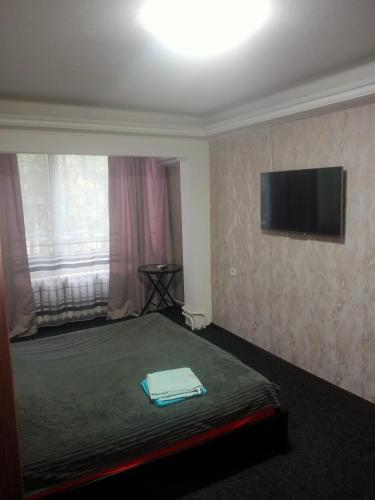 基辅однокомнатная квартира的酒店客房,设有一张带平面电视的床铺。