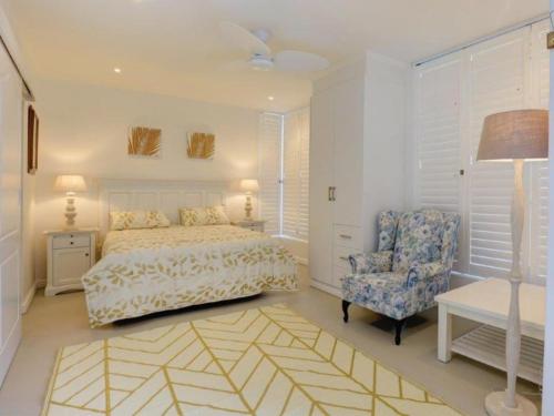 乔治Beautiful Gate的一间卧室配有一张床、一把椅子和一盏灯