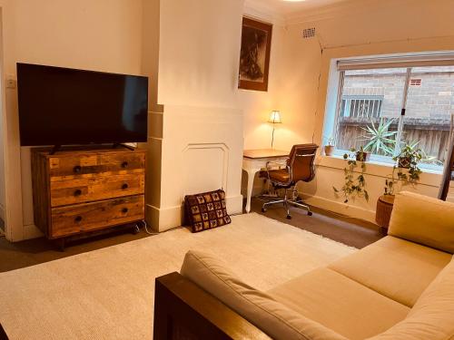 悉尼Little White Heaven - shared apartment的带沙发和平面电视的客厅