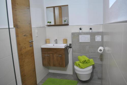 韦伯格Ferienwohnung Gipfelblick的浴室设有卫生间和带黄毛巾的盥洗盆。
