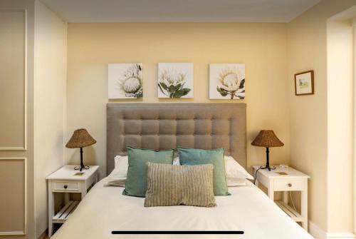 开普敦Guest suite - Leafy Constantia Guest House的一间卧室配有一张带2个床头柜的大床