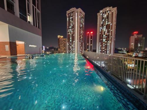 吉隆坡Chambers Residences Suites KLCC的一座游泳池,在晚上在一座建筑的顶部