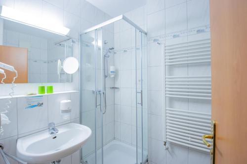 诺伊豪森Ferien Hotel Spree-Neisse的带淋浴和盥洗盆的白色浴室