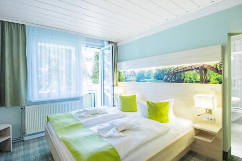 诺伊豪森Ferien Hotel Spree-Neisse的卧室配有一张带黄色枕头的大型白色床。