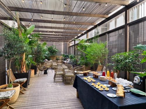 巴塞罗那加泰罗尼亚广场H10精品酒店的庭院配有桌椅和植物