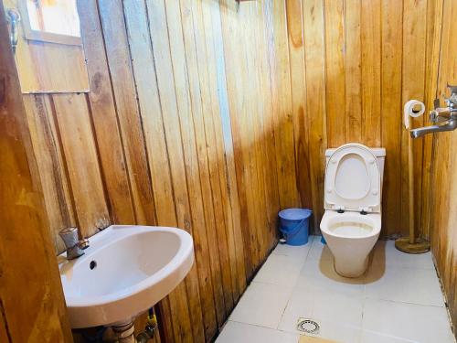 KibuyeKivu Macheo eco-lodge的木制浴室设有卫生间和水槽