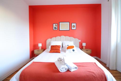 贝尔热拉克Le Boho - Charmant T3 - gare à 5 min à pieds的红色卧室设有白色的床铺和红色的墙壁