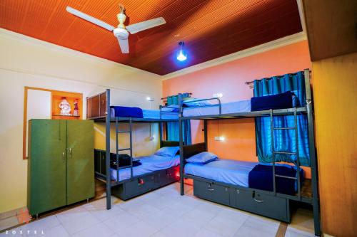 迈索尔Zostel Mysore的带吊扇的客房内的两张双层床