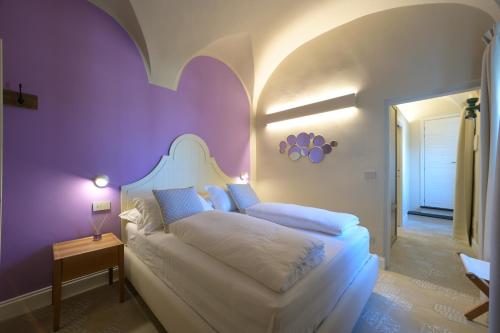 玛丽安迪安多拉Muri Vecchi的卧室配有白色的床和紫色墙壁