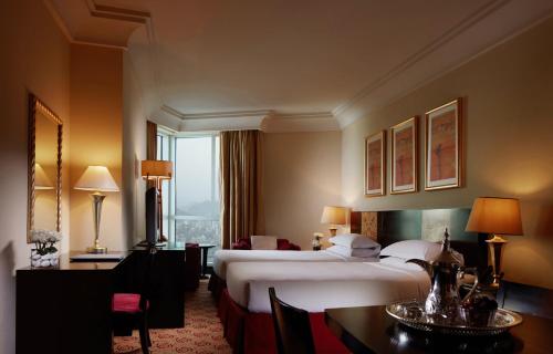 麦加普尔曼赞姆赞姆麦加酒店的酒店客房带两张床和一张桌子以及椅子。