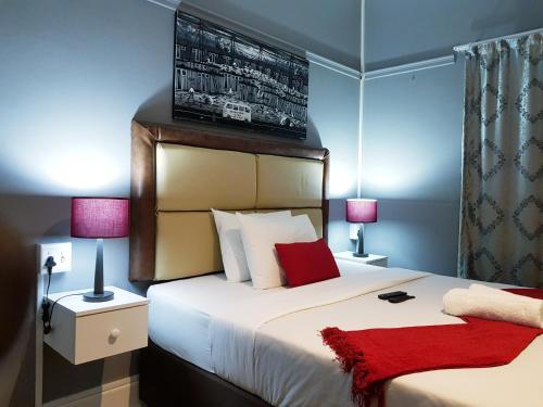 伊丽莎白港Kingsworth inn Port Elizabeth的卧室配有带红色枕头的大型白色床